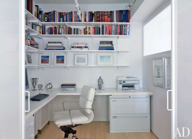 white office with colourful books and artwork 